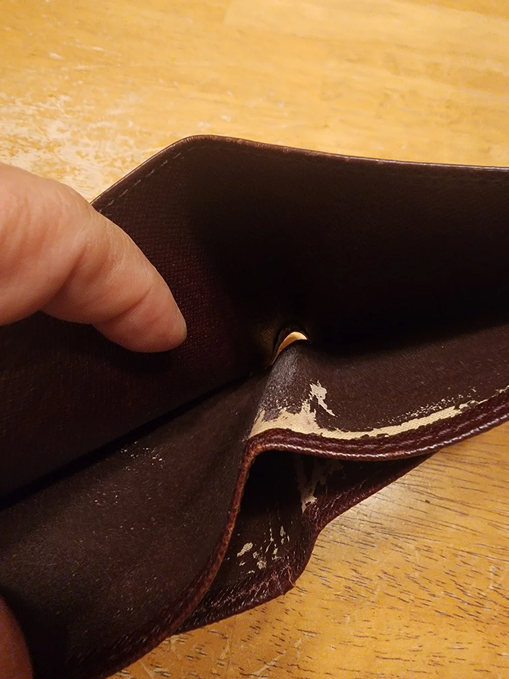 burgandy Louis Vuitton Taiga leather bifold wallet featuring a debossed LV